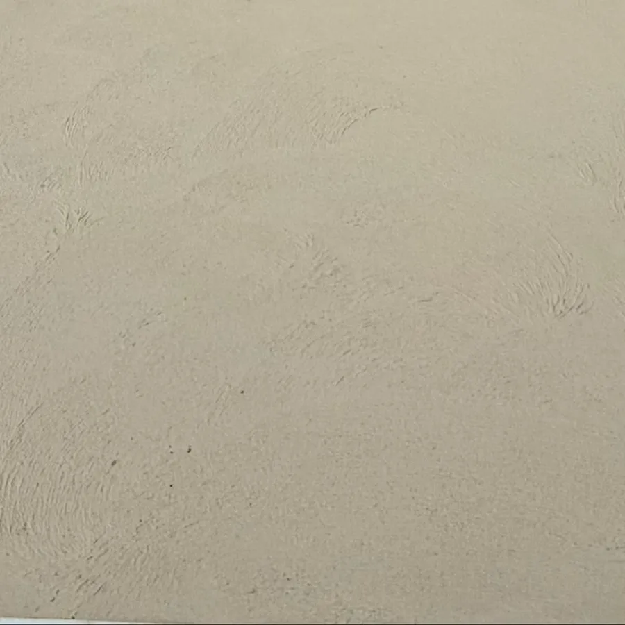 Close view of cream coloured concrete: one even tone across the whole surface with a fine broomed texture and no stones showing